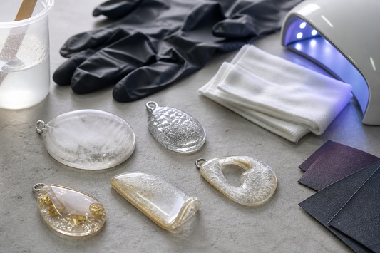 Several failed resin jewelry pieces showing tacky surfaces, cloudiness, trapped bubbles, warping, and a large void on a clean repair workspace