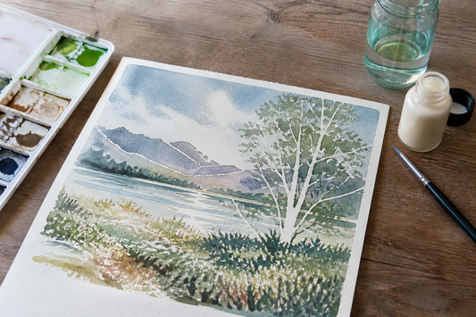 Watercolor masking fluid preserving small white highlights and branches in a partially painted landscape